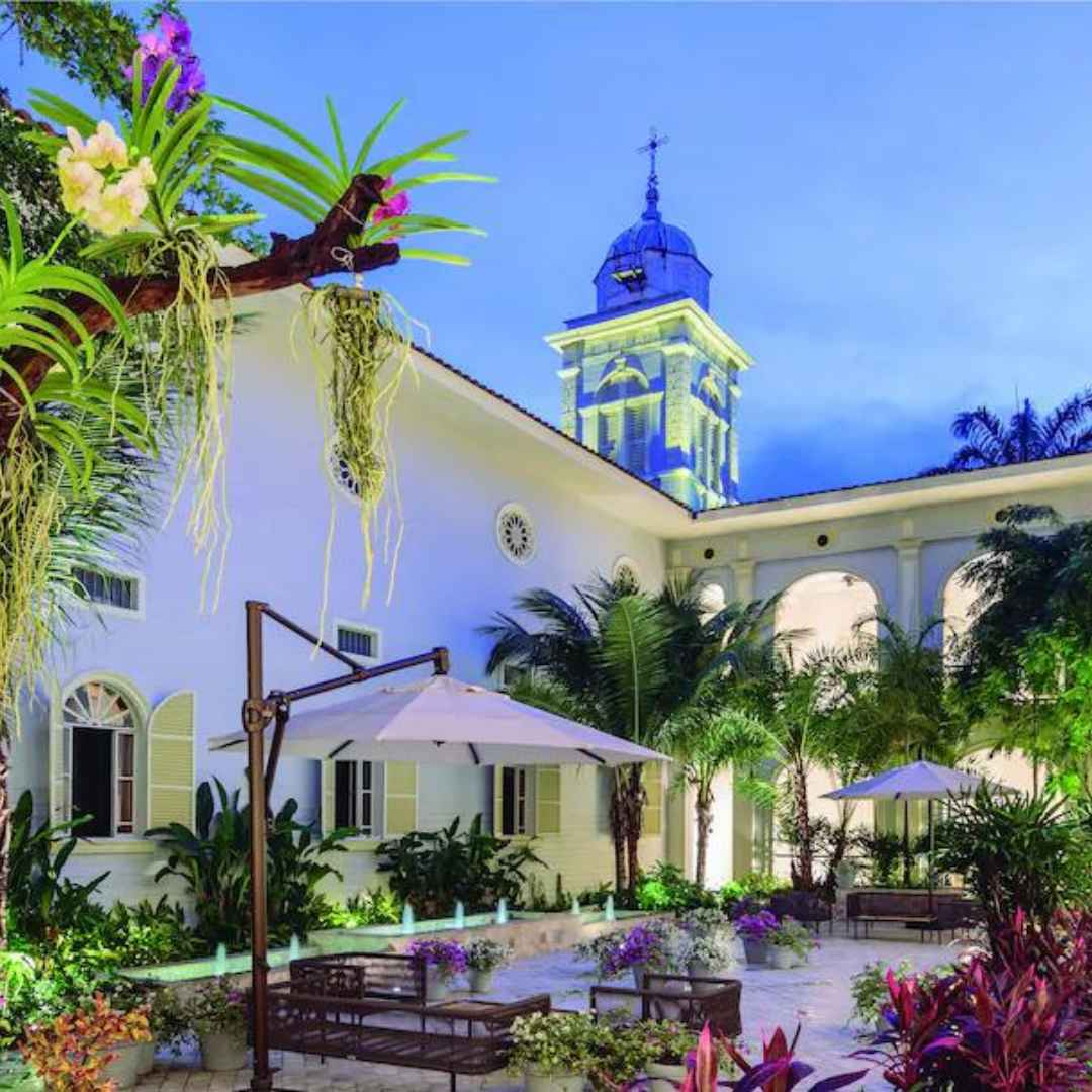 A captivating photograph showcasing the lush interior garden of Hotel del Parque in Guayaquil. Elegant pathways wind through the meticulously landscaped garden, offering inviting seating areas for guests to relax and immerse themselves in the tranquil botanical oasis within the hotel.