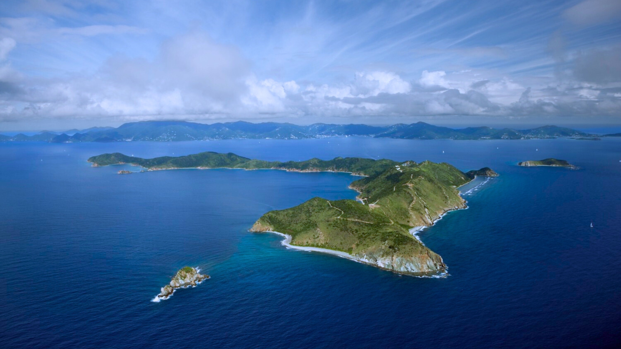 A stunning aerial vista of Peter Island in the British Virgin Islands, with its azure waters and lush tropical landscape. Tailored for self-flying pilots planning a Caribbean adventure