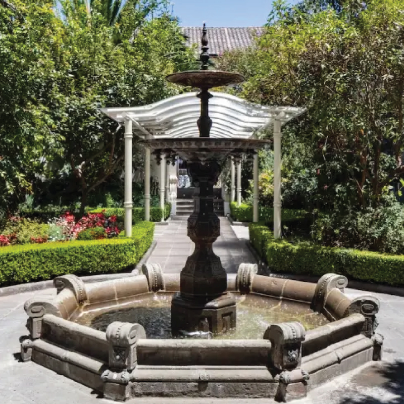 A serene garden oasis at Casa Gangotena in Quito, Ecuador, featuring lush greenery and tranquil pathways. A delightful retreat for self-flying pilots exploring South America, the Casa Gangotena Garden offers a peaceful respite amidst the bustling cityscape, perfect for relaxation and rejuvenation after soaring through Ecuador's skies.