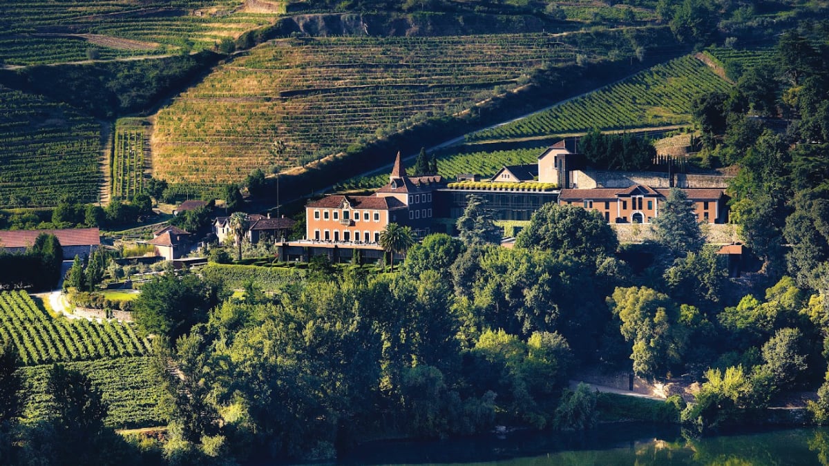 A breathtaking view of Six Senses Douro Valley in the picturesque Douro Valley, Portugal, nestled amidst terraced vineyards and rolling hills. Tailored for self-flying pilots planning a European adventure