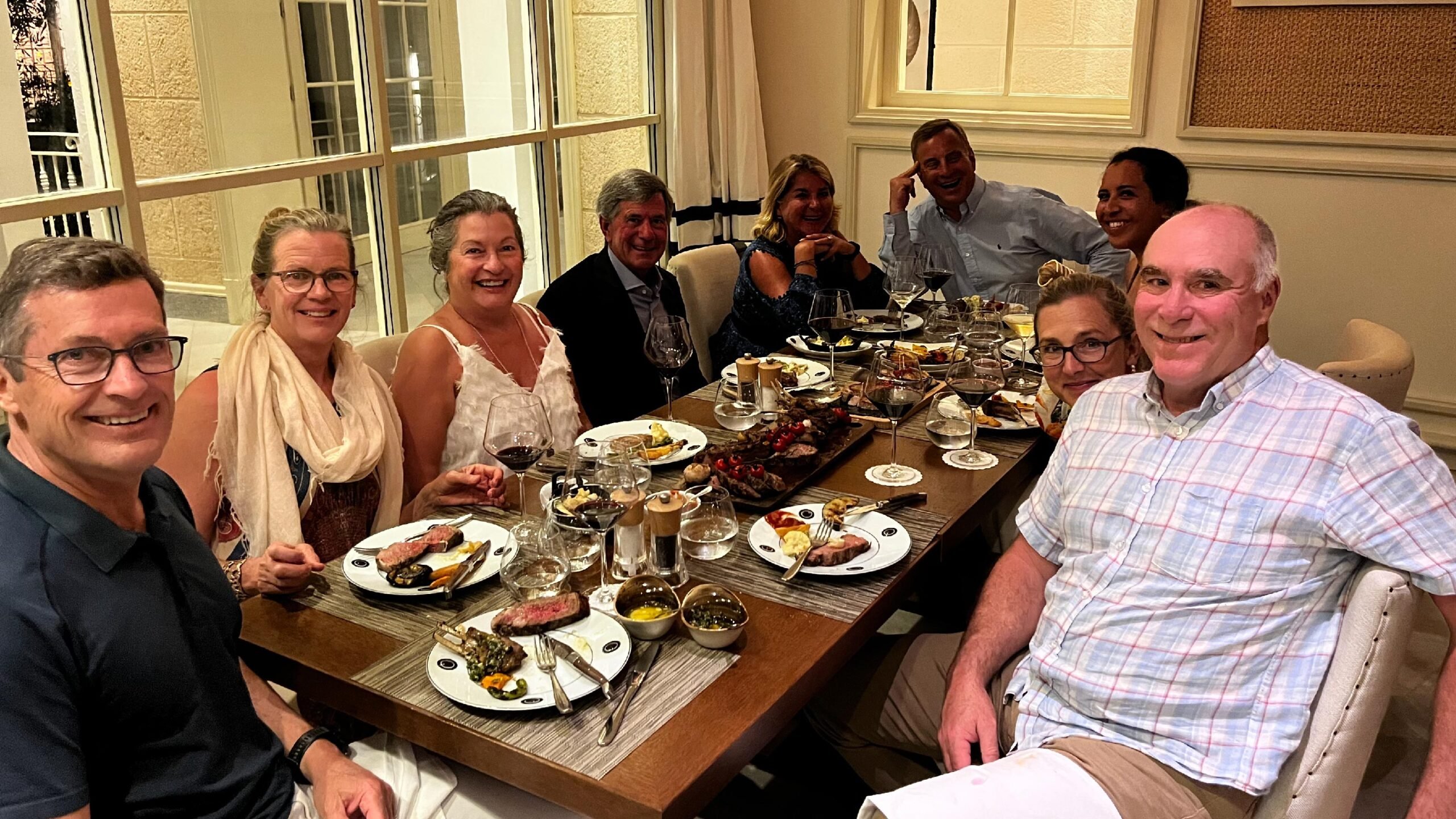 A group of travelers poses together at a dinner table in Canouan, Grenadines.