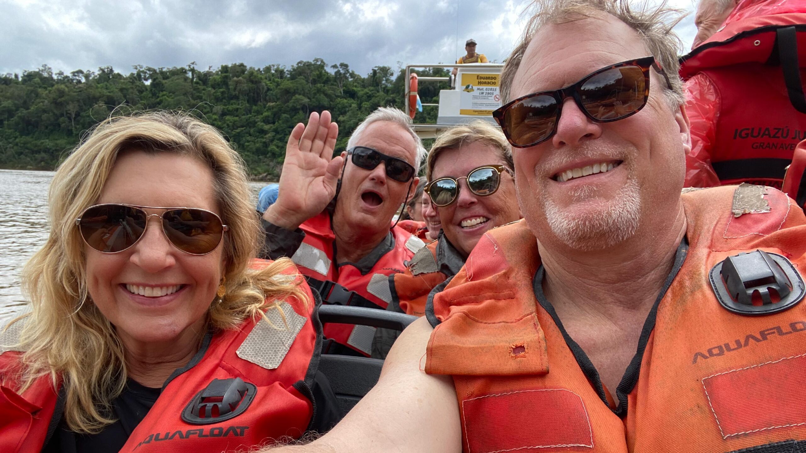 A group of travelers poses on a boat during a tour through Iguazu Falls in Brazil.