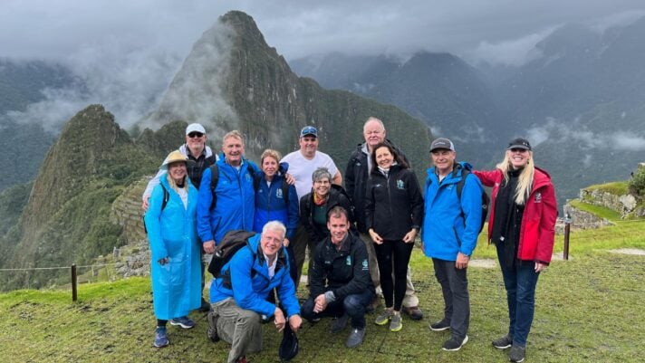 Adventurers enjoying the amazing vista of Machu Picchu, Peru