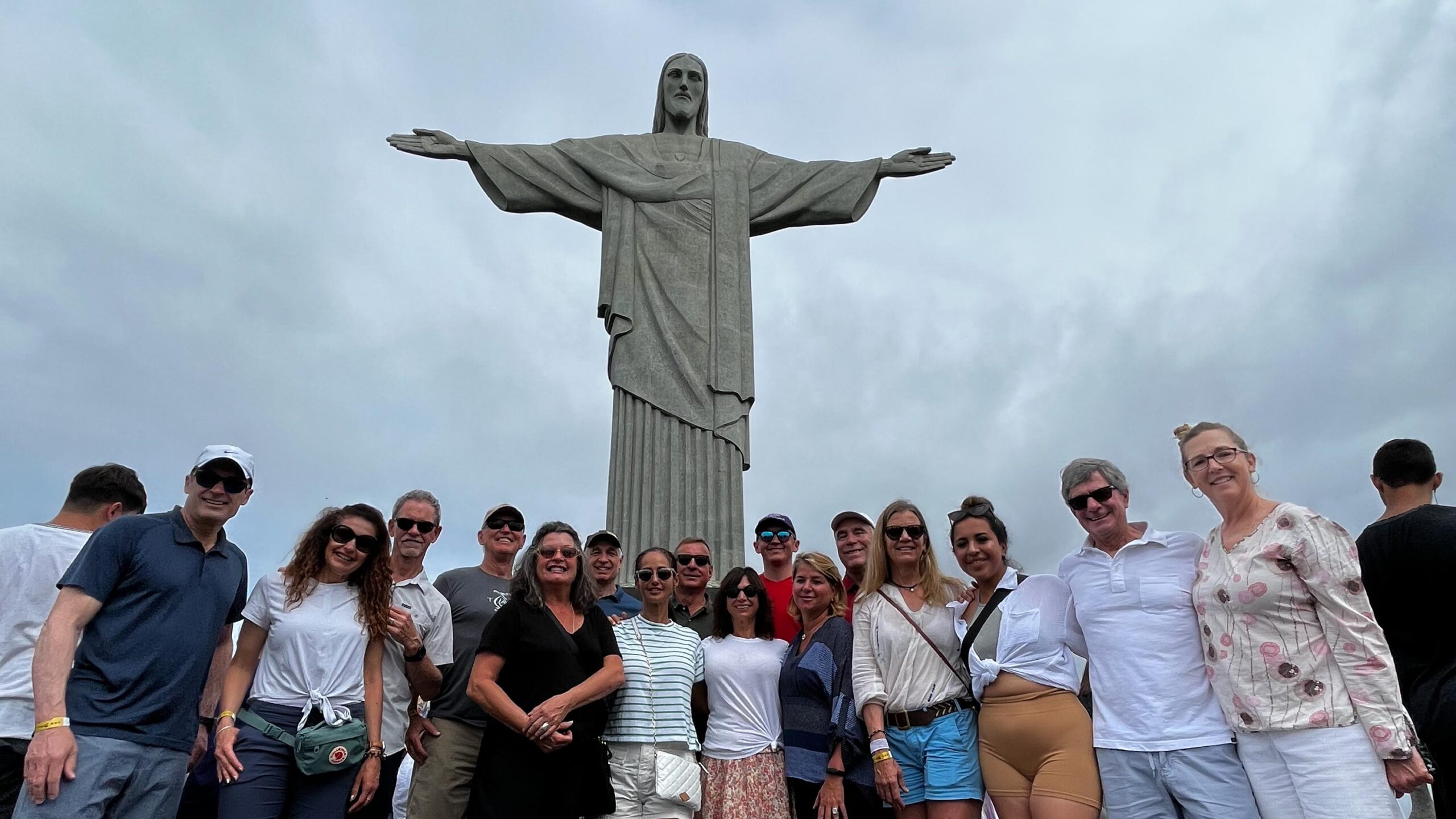 A group of travelers poses in front of the Christ the Redeemer statue on Corcovado Mountain in Rio de Janeiro, Brazil.