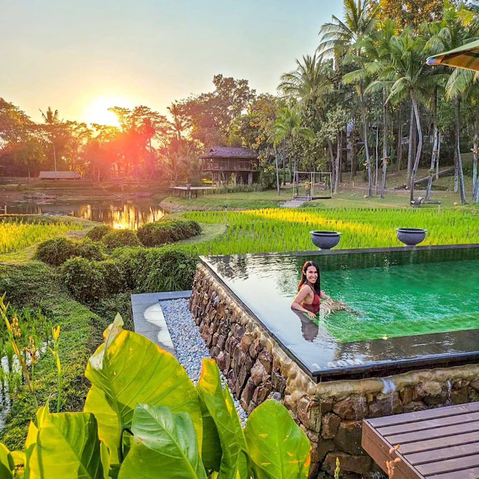 Woman relaxing at pool of the Four Seasons Resort Chiang Mai