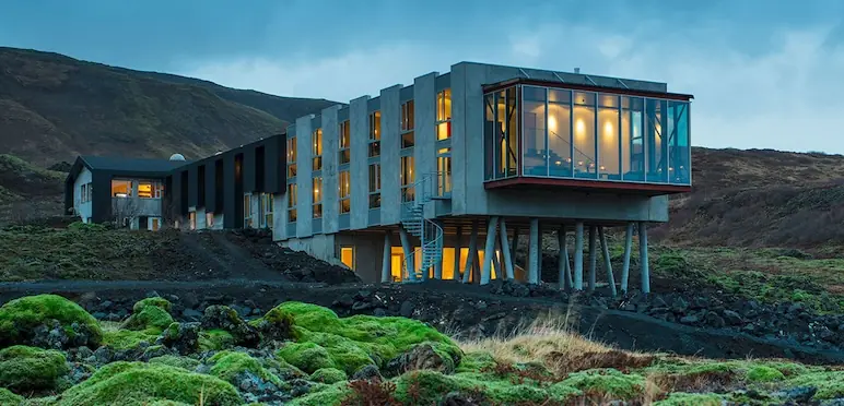 A stunning view of the Ion Hotel nestled in Iceland's breathtaking natural surroundings, offering a luxurious retreat for travelers on a self-flying journey through the country