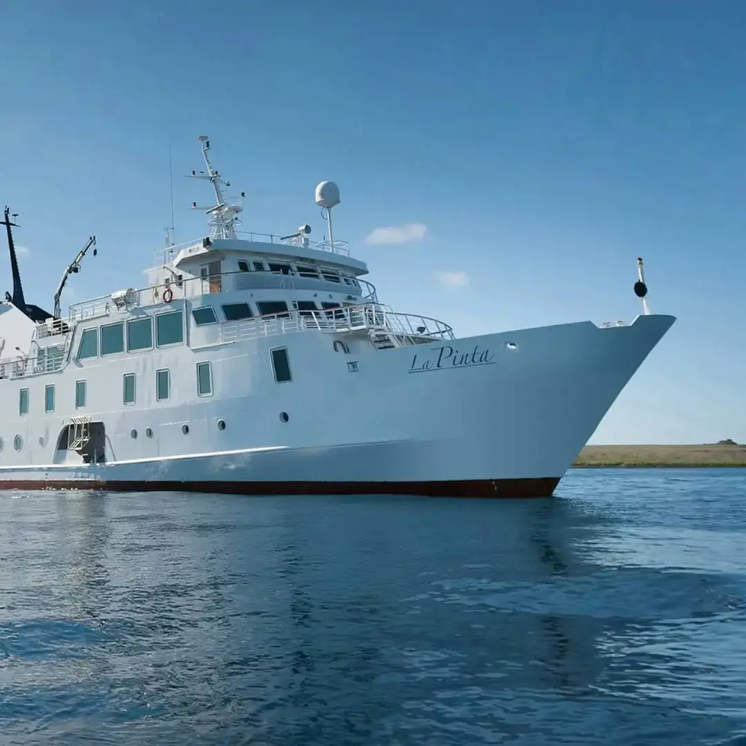 The elegant and sophisticated Yacht La Pinta as it gracefully navigates the turquoise waters surrounding the Galapagos Islands.