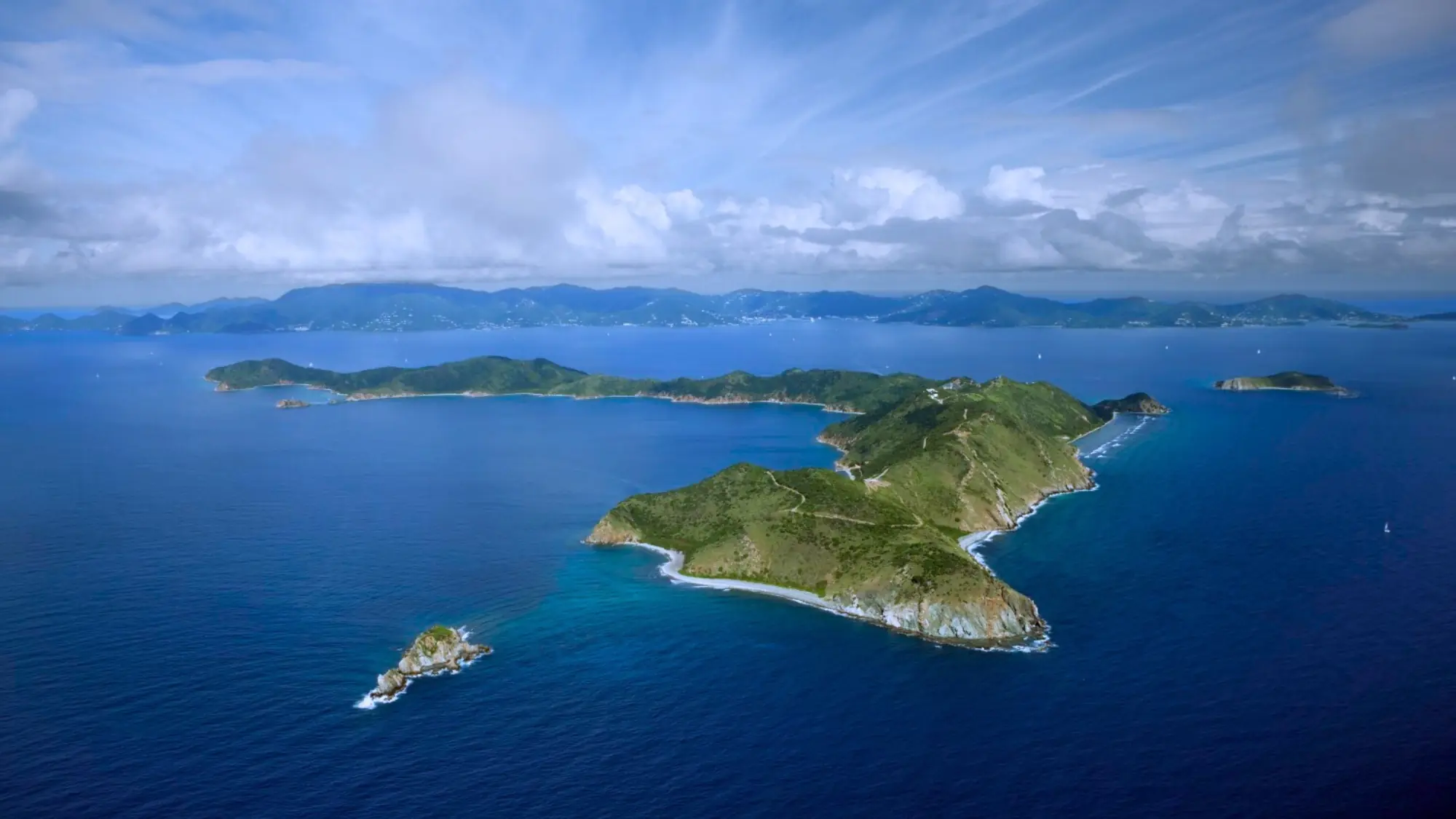 A stunning aerial vista of Peter Island in the British Virgin Islands, with its azure waters and lush tropical landscape. Tailored for self-flying pilots planning a Caribbean adventure